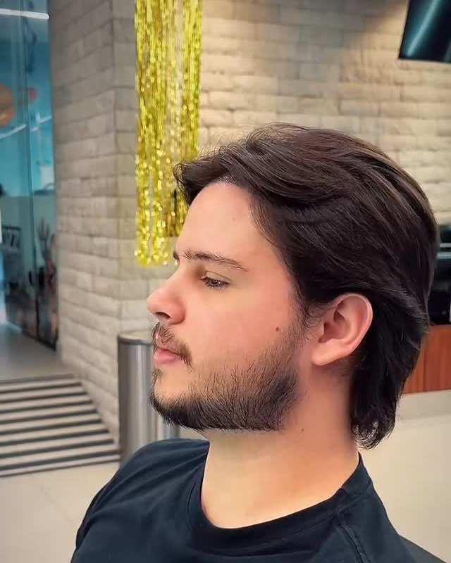 Cliente de perfil com cabelo médio e barba alinhada